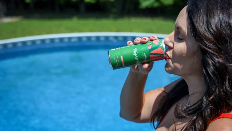 Woman sipping Wunder’s Higher Vibes Watermelon Basil cannabis drink by the poolside