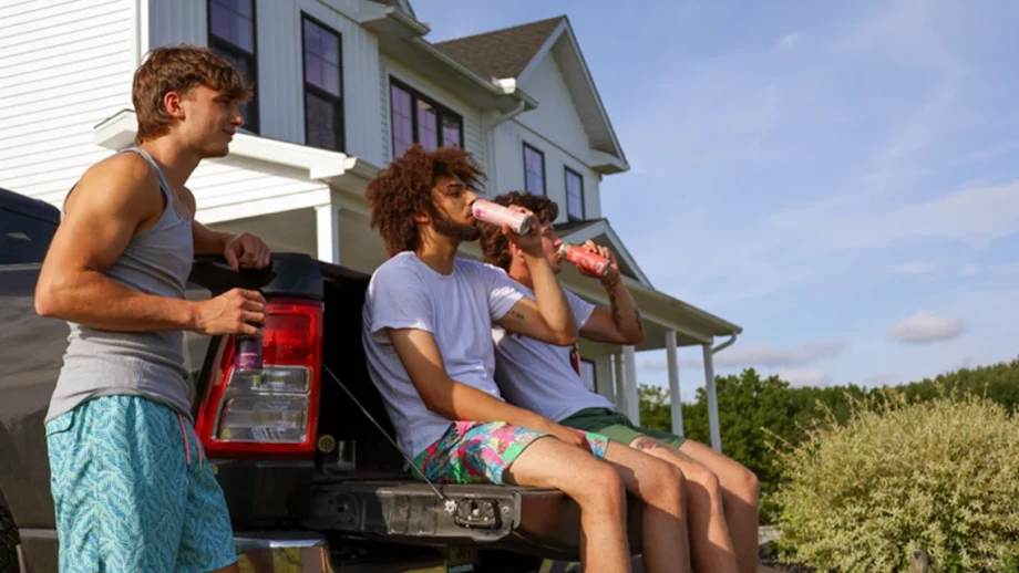 Three guys practicing mindful drinking by sipping Wunder beverages on the back of a pick-up truck