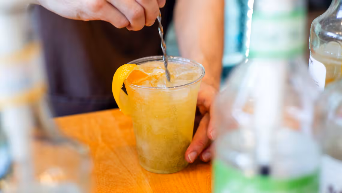 close-up photo of a man mixing a Super Bowl beverage on his counter